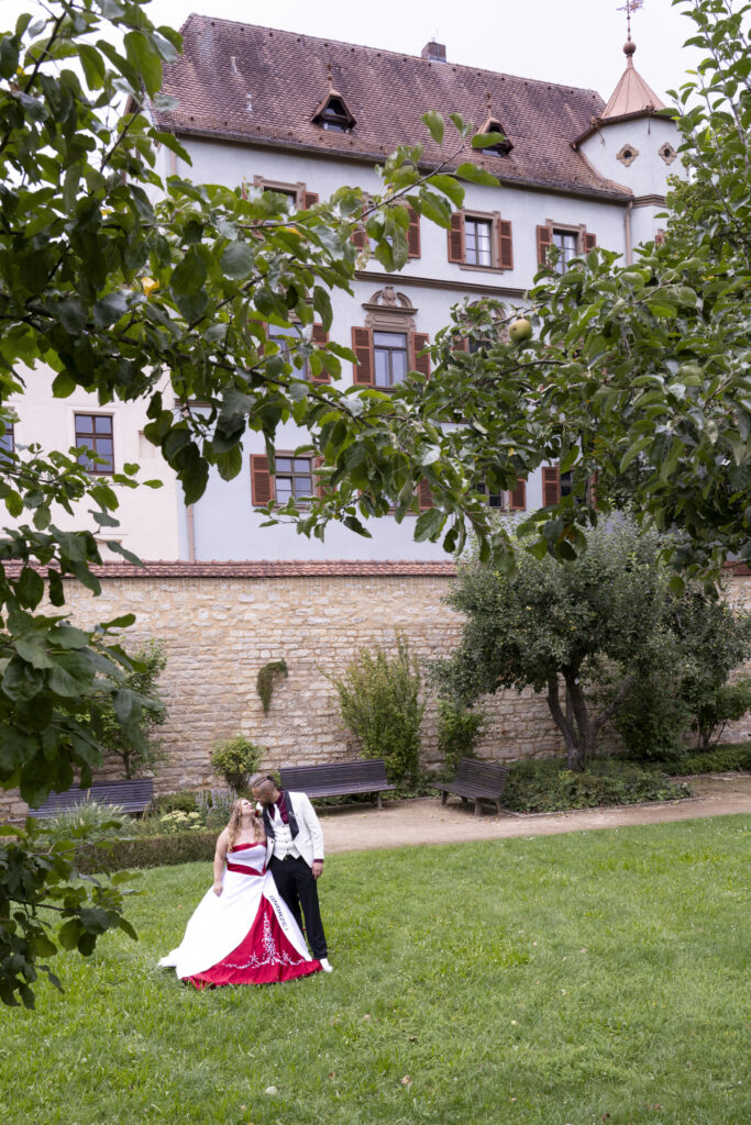 Hochzeit im Standesamt Schloss Treuchtlingen. Das Brautpaar küsst sich im Schlosspark.
