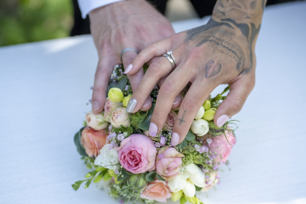Hände auf dem Brautstrauß