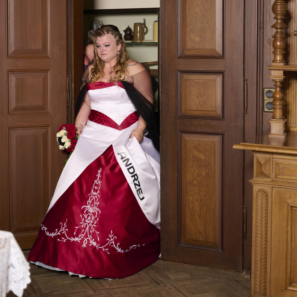 Hochzeit im Standesamt Schloss Treuchtlingen. Die Braut kommt durch die getäfelte Holztür des Standesamtes.