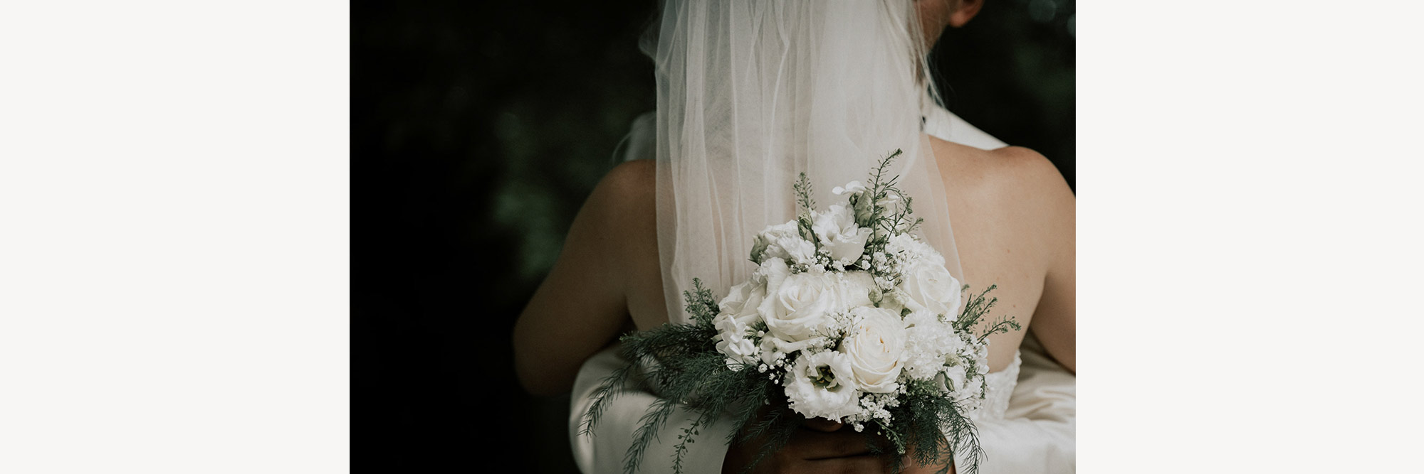 Braut von hinten mit Brautstrauß cor dem Rücken
